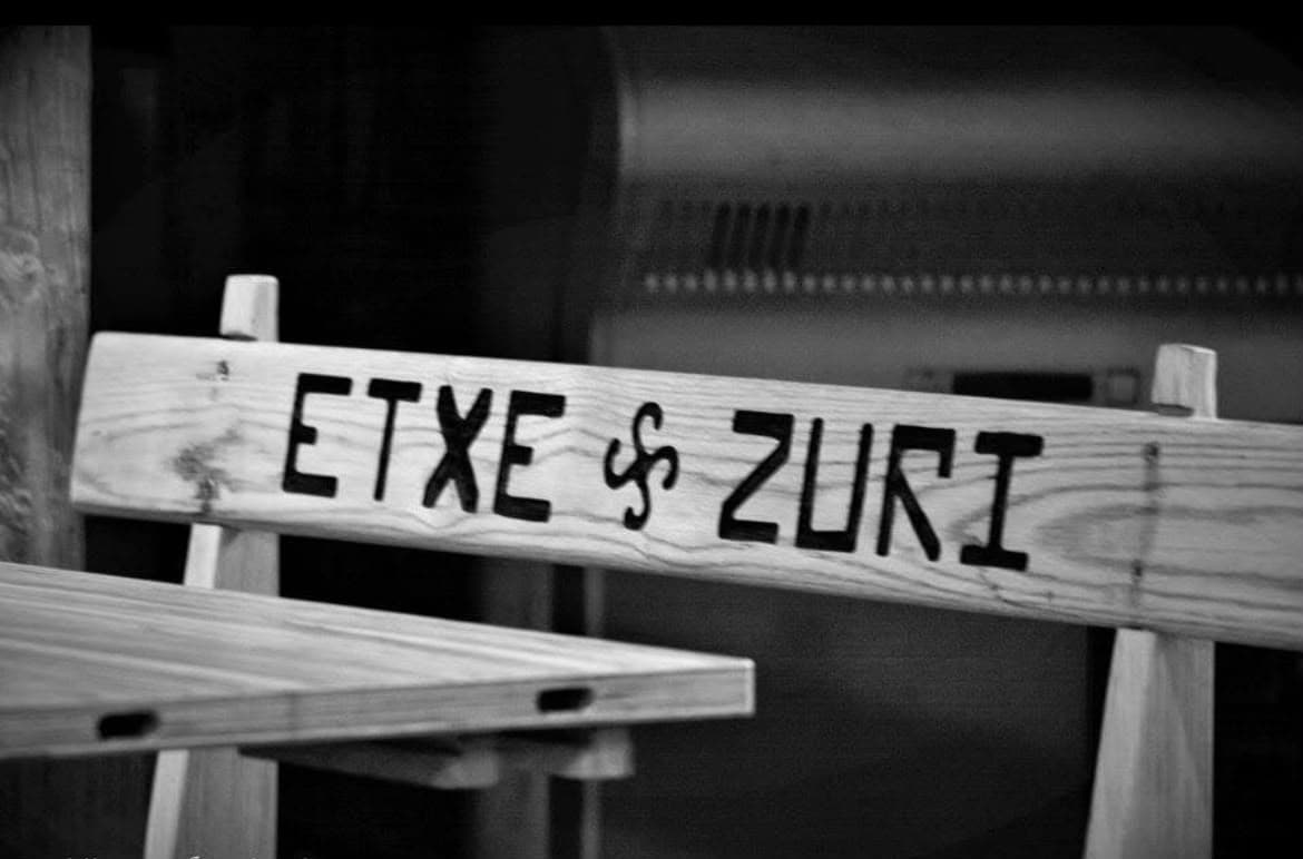 'Etxe Zuri' izena eta lauburua tailatuta dituen bankua