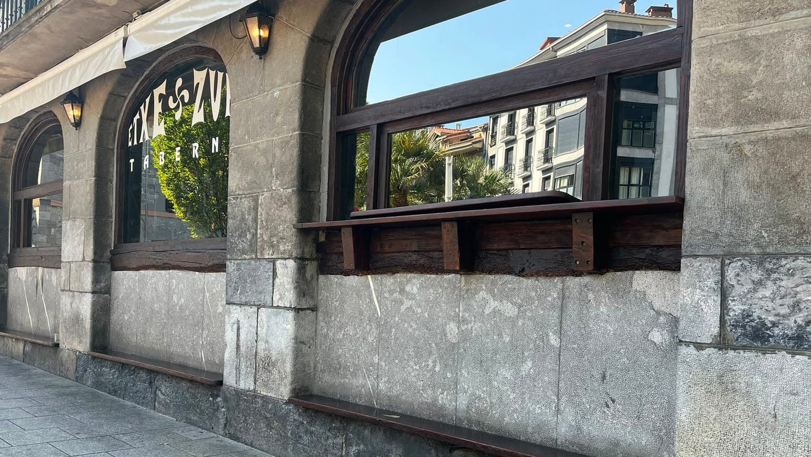 Kanpoaldeko harrizko arkuak, zurezko poyeteak eta faroltxoak, eguzkitan